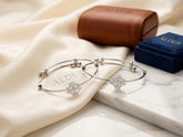 Alder Snowflake Crystal Bangle Set with two silver bangles and Alder gift boxes on marble