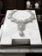 Ruby Floral Cascade Gold Necklace on cream fabric